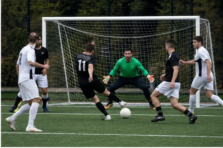 Giocatori di calcio a 5 in azione davanti a una porta con rete.