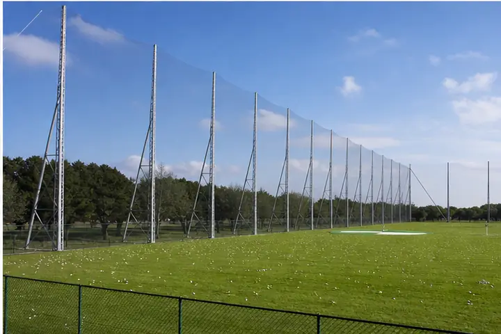 Alte reti di contenimento installate lungo un driving range.